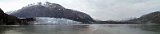 Alaska Trip - Glacier Bay Cruising - Tarr Inlet - Margerie and Grand Pacific Glaciers Panorama - Monday, the first full day of the cruise, was spent at sea, traveling from Seward to Glacier Bay. There was nothing to see except water. We arrived at the mouth of Glacier Bay 8:30 am on Tuesday Morning. As late as 1794 the Grand Pacific Glacier extended to the mouth, presenting explorers with a wall of ice 2 miles wide and 4000 feet high. Shortly thereafter the glacier began to retreat up the bay with its current location being ~65 miles from the mouth of the bay. This is a panoramic picture made from five photographs taken at the head of Tarr Inlet at the end of the bay. On the right is the Grand Pacific Glacier. Since it is covered by rock debris from landslides and medial moraines it is almost unrecognizable as a glacier. According to one of the National Park Service Rangers on board the Zaandam for this portion of the cruise, the debris is up to 3 feet thick. She referred to it as a "black" glacier. It begins on the southern slopes of Mt Hay in the Saint Elias Mountains and flows for 35 miles first east through British Columbia, then south to Tarr Inlet. At its terminus it is almost 2 miles wide and is the widest glacier in the bay. The ice is about 150 ft thick, extending about 50 feet into the water. All the dirt on the glacier serves to insulate it so calving is relatively rare. On the left of the panorama is the more recognizable Margerie Glacier. Its source is on the southern slopes of Mount Root. It flows for 21 miles to the northeast also to Tarr Inlet. At its terminus the glacier is a little over 1 mile wide. The face is 250 feet high above the water, and it descends 100 feet into the water. It is this latter depth which allows large cruise ships such as the Zaandam to park close to its face. The ice flows at about 6 feet per day, so calving is common. There were three such events during our 2 hour stay at the inlet. I captured one of them in the photographs in the next picture collage. Due to the ship's location in the inlet, this panorama covers about 90 degrees. Margerie Glacier is closer and perpendicular to the Grand Pacific Glacier. Thus the distortion in their size and relative widths. One little personal note. The ship was serving hot chocolate while we were at Grand Pacific and Margerie glaciers. I purchased a large Holland America mug to have it in, and asked the waiter to "put a squirt of mint in it". Well, we had a failure to communicate. It came with a shot of Crème de Menthe. Well I wasn't about to let a large mug of hot chocolate go to waste, and after all, maybe the hot chocolate would evaporate the ethanol (in the closed container. Oh well, I guess I had more to drink on this cruise than I had in my previous 6+ decades :) Alaska Trip - Glacier Bay Cruising - Tarr Inlet - Margerie and Grand Pacific Glaciers Panorama